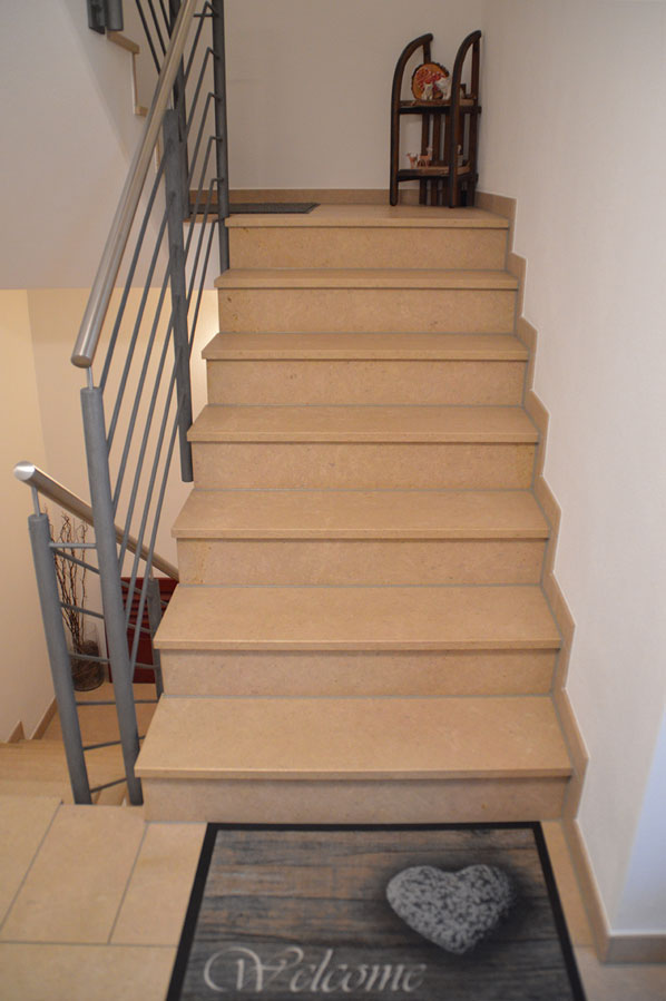 Helle Treppe in Sandstein-Optik mit Metallgeländer und sauberen Kanten