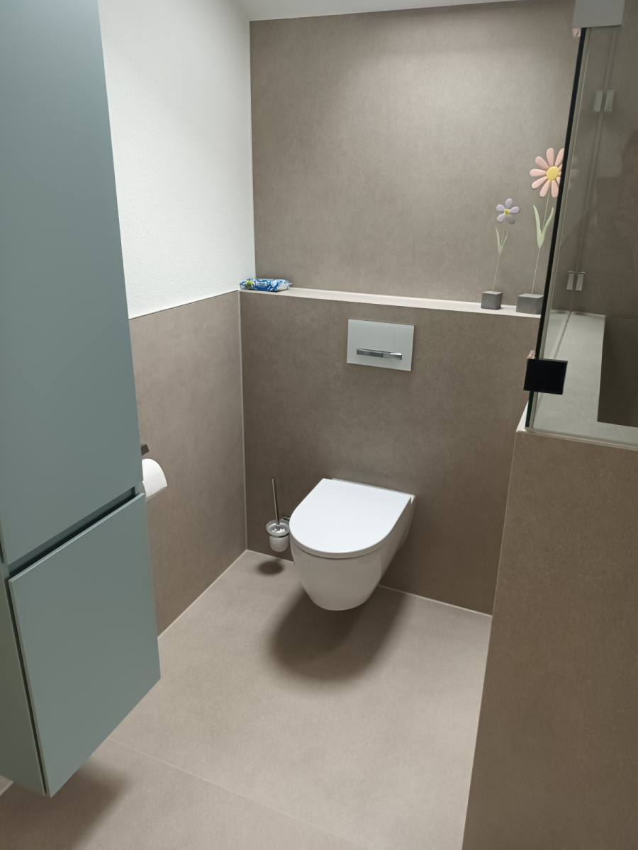 Modernes Gäste-WC mit wandhängendem WC, beigen Fliesen in Betonoptik und Ablagevorsprung