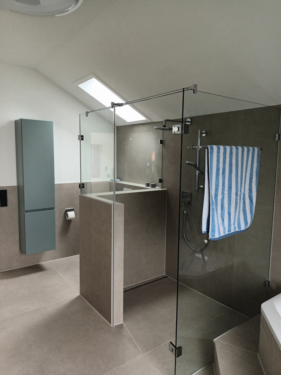 Geräumiges Badezimmer unterm Dach mit rahmenloser Glasdusche, Dachfenstern und dunkelgrauen Akzentfliesen